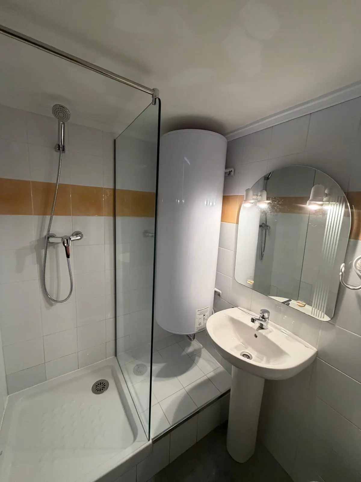 Baño terminado con la ducha y el termo reubicados